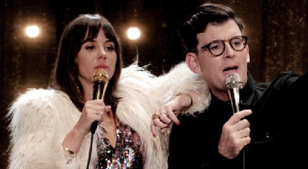 A picture of Moshe Kasher and Natasha Lehhero holding the mic in their show The Honeymoon Stand Up Special.