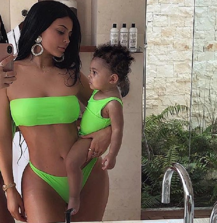 Kylie Jenner with her baby in a matching colored swimsuit.