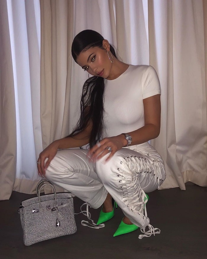 kylie in all white outfit with neon shoes.