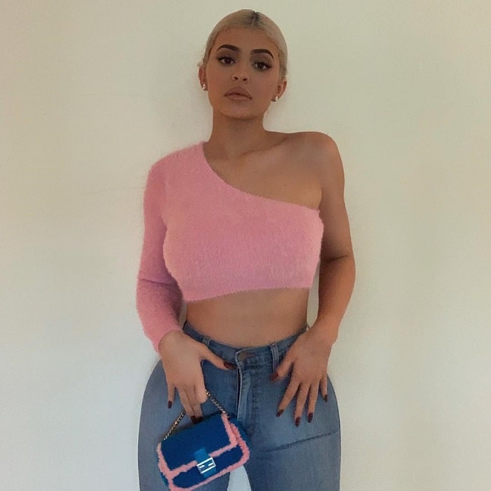 Kylie in a pink sweater and blue jeans.