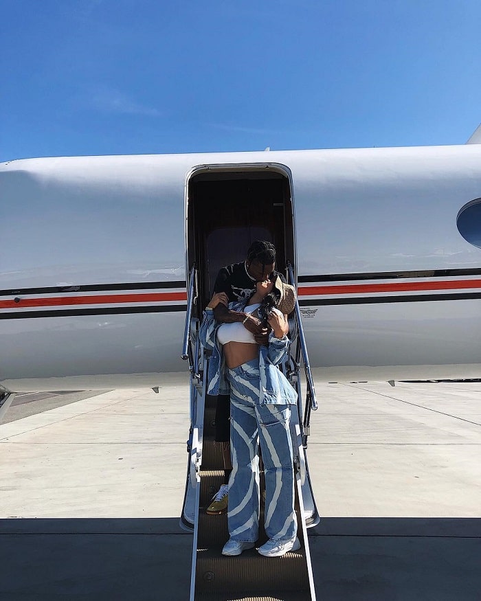 Kylie and Travis Scott kissing outside their airplane. 