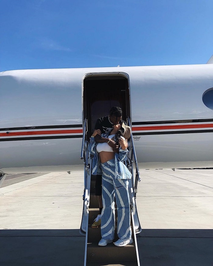 Kylie and Travis Scott kissing outside their airplane. 