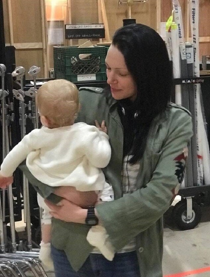Ella being held by her mommy on her show set.