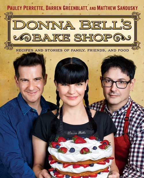 Pauley Perrette with on the cover picture of her book Donna Bell's Bake Shop with her best friends. 