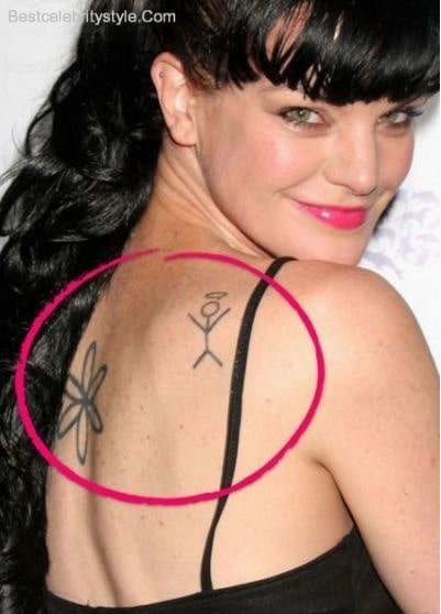 Pauley Perrette showing her daisy flower and stick figure tattoo.