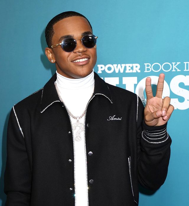 Michael Rainey Jr. posing with a peace sign wearing white turtle neck and black bomber jacket