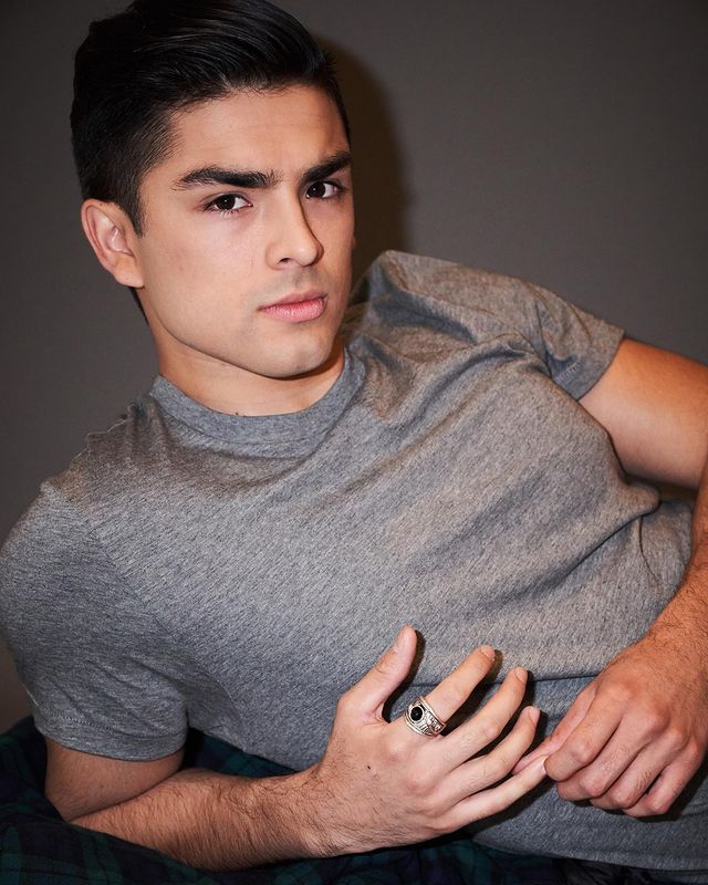 Diego is wearing a grey tee.