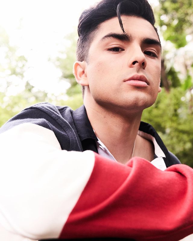 Diego is wearing a black white and red color jacket.