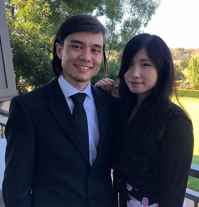 Matt Stonie with his girlfriend wearing a black suit