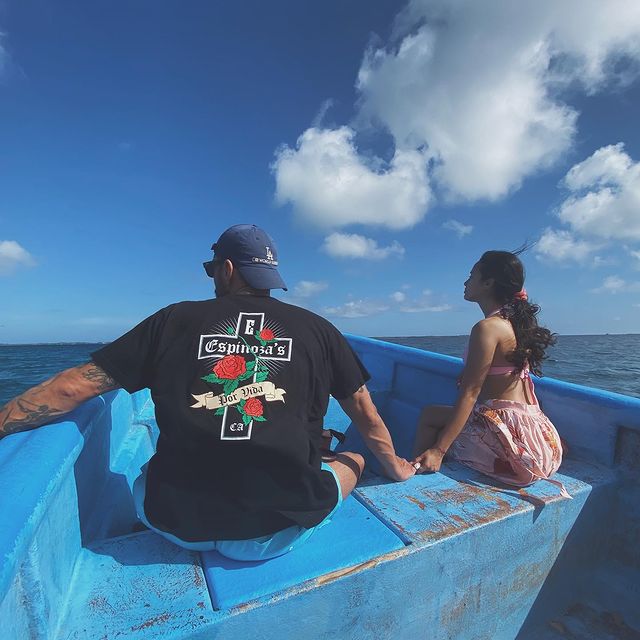 Emily Tosta with her boyfriend in a boat wearing a baby pink color swimsuit