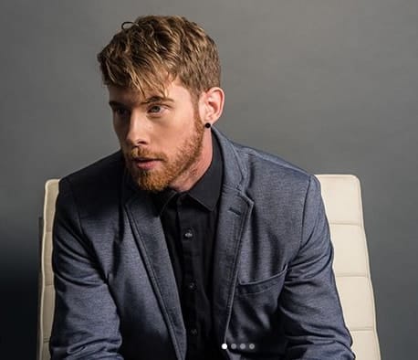 Picture of Brandon Farris posing for a photo wearing classic black suit