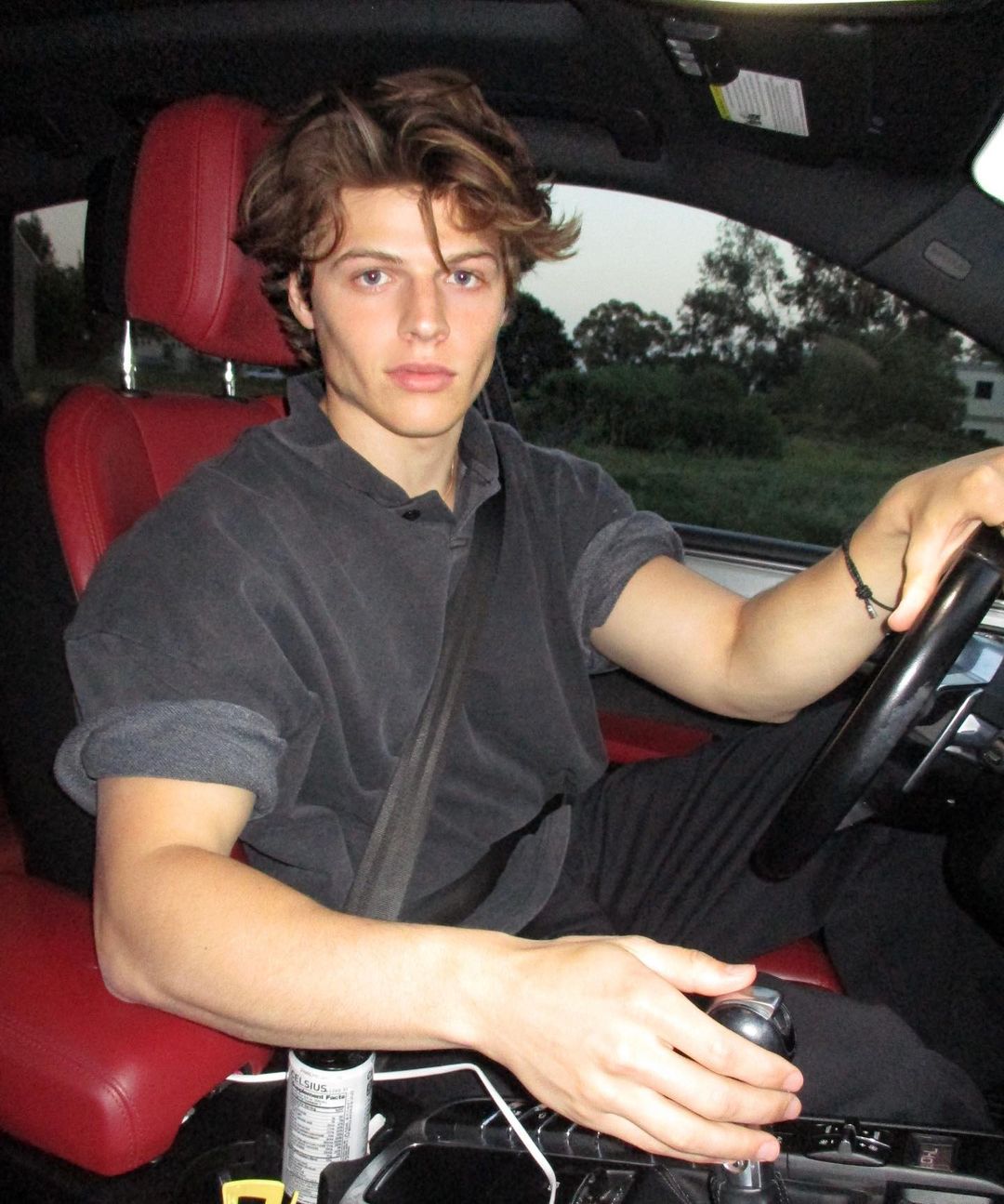 Sam Dezz posing for a photo shoot in his car. 
