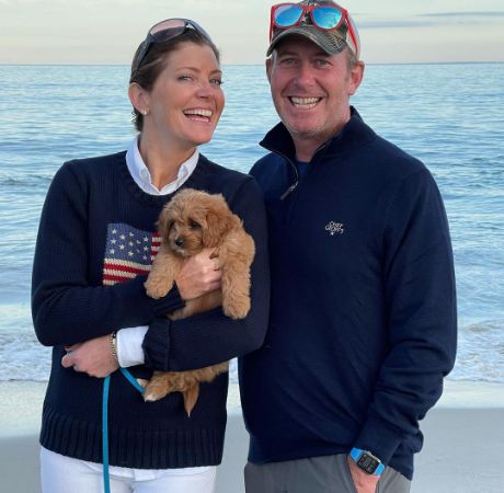 Riley Norah Tracy's parents posing for a photo shoot while holding a cute dog.