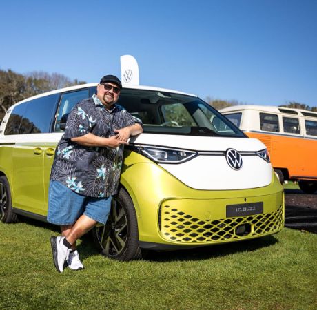 Gabriel Iglesias posing with his Volkswagen.